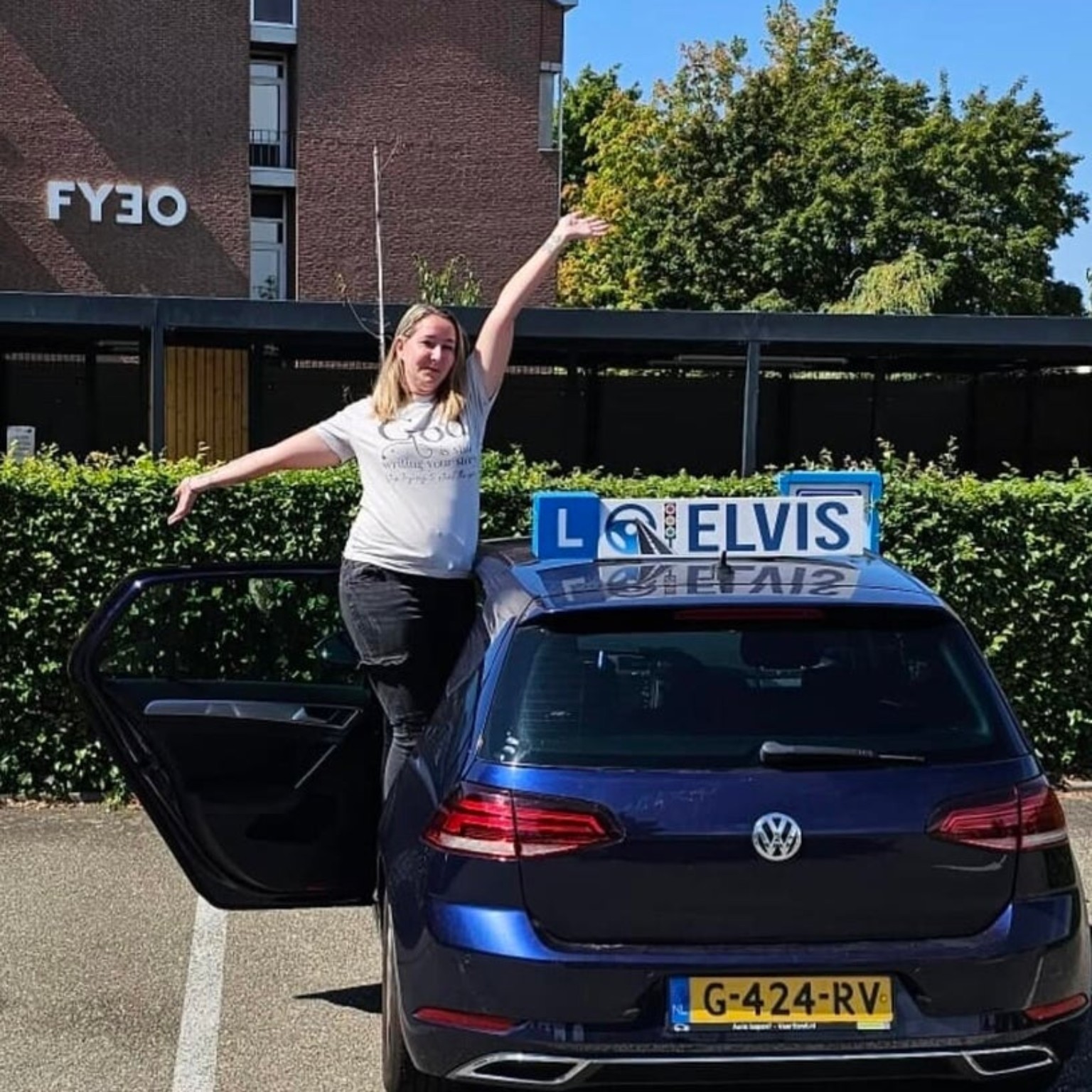 Rebecca Deschaux-Aarts beside the Rijschool Elvis lesson car